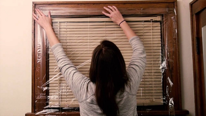 Woman applying plastic window film